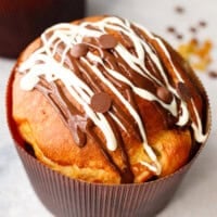 kulich easter bread baked in paper mold with chocolate drizzle on top