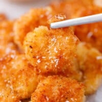 Crispy coconut shrimp held on a fork showing golden crunchy coating