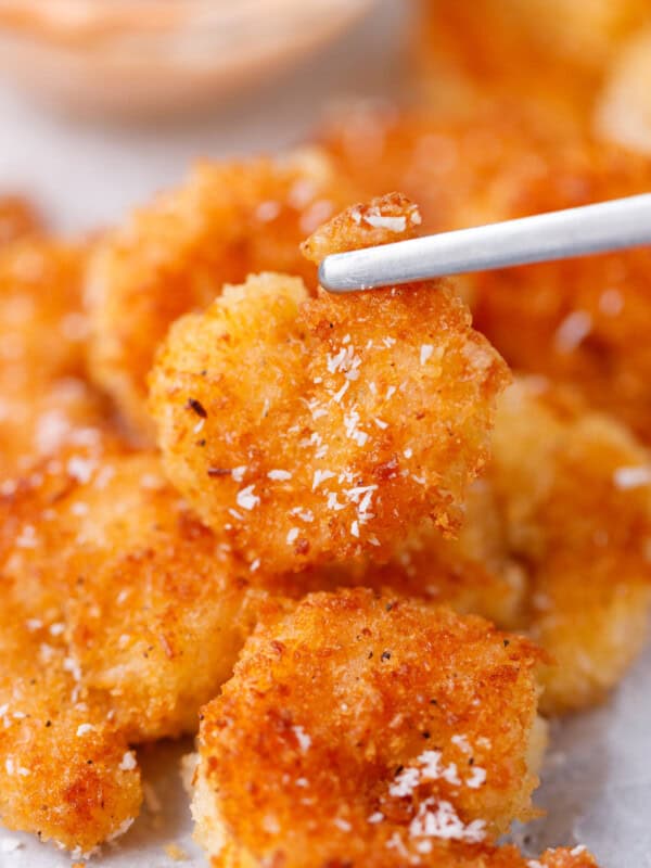 Crispy coconut shrimp held on a fork showing golden crunchy coating