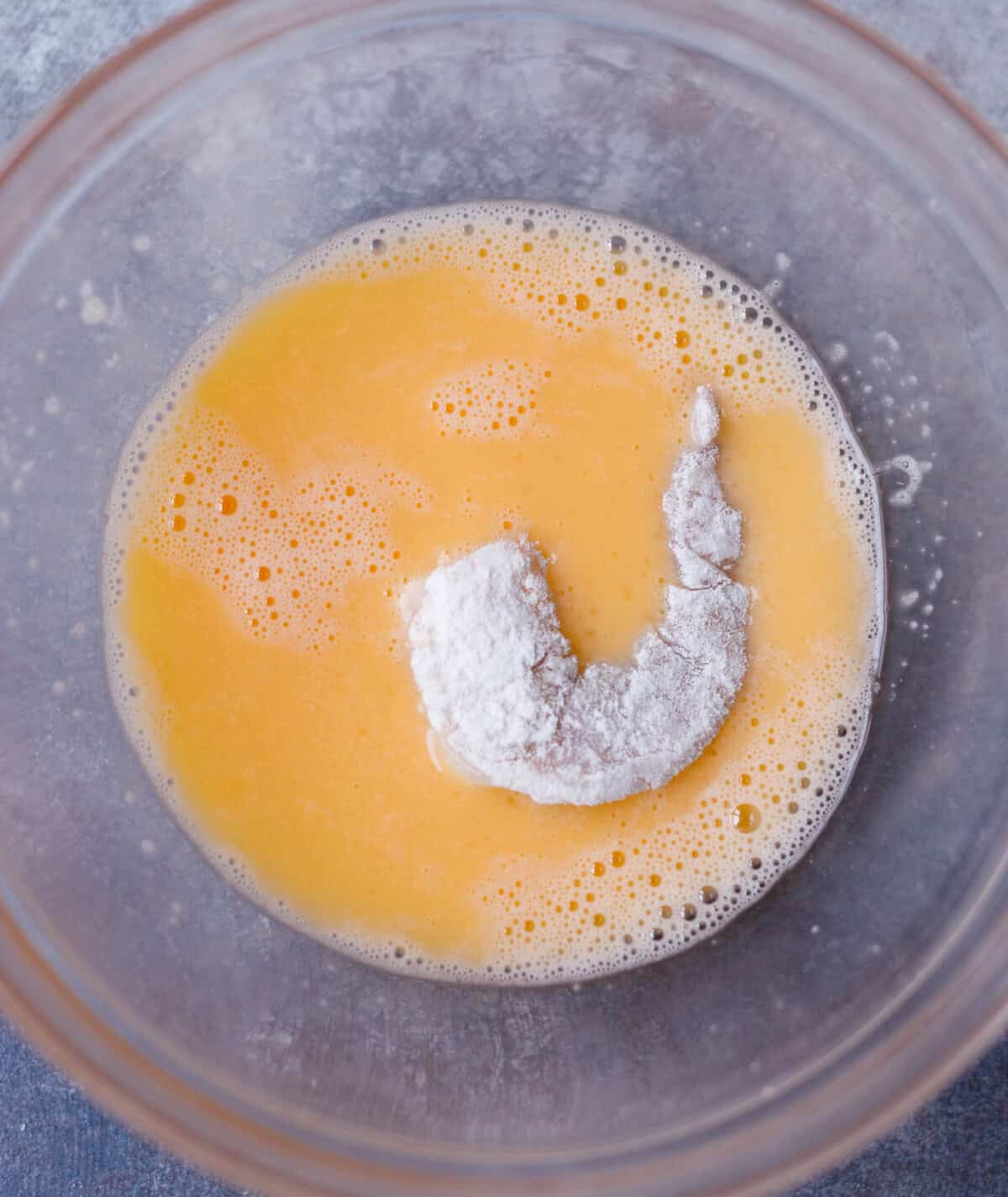 Floured shrimp dipped into beaten eggs for coconut shrimp recipe