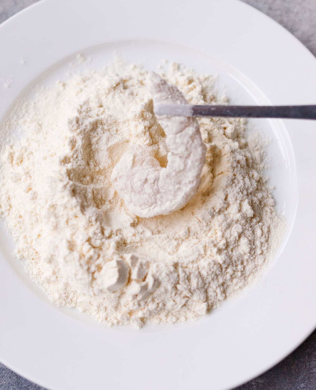 Raw shrimp coated in flour for coconut shrimp breading process