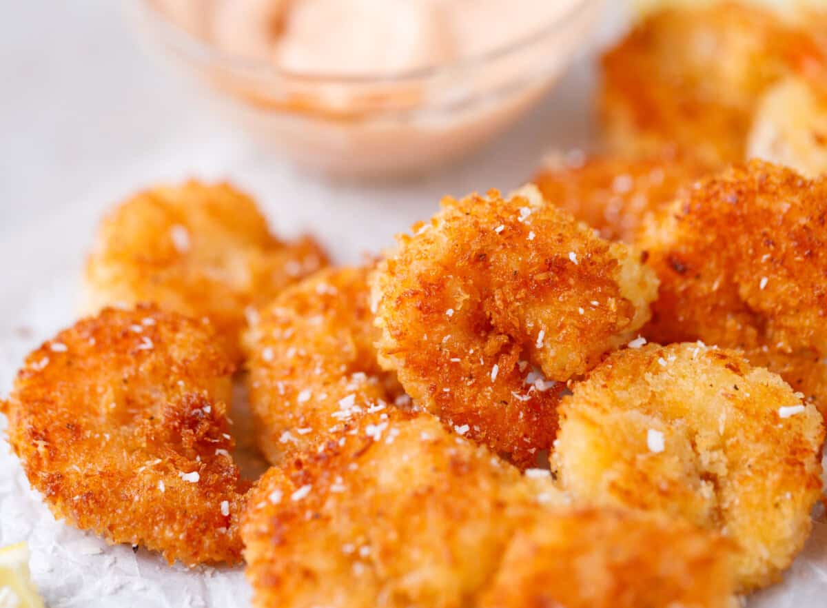 Crispy coconut shrimp served with creamy dipping sauce in the background