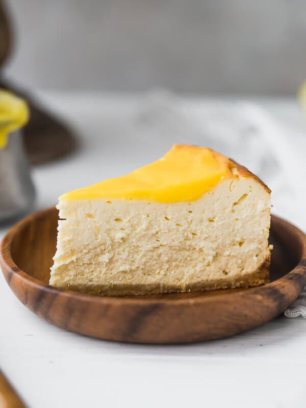 slice of lemon keto cheesecake with creamy texture and almond flour crust on wooden plate