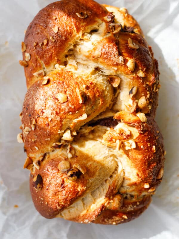 Close-up of braided whole wheat Easter bread kozunak topped with chopped hazelnuts and golden crust