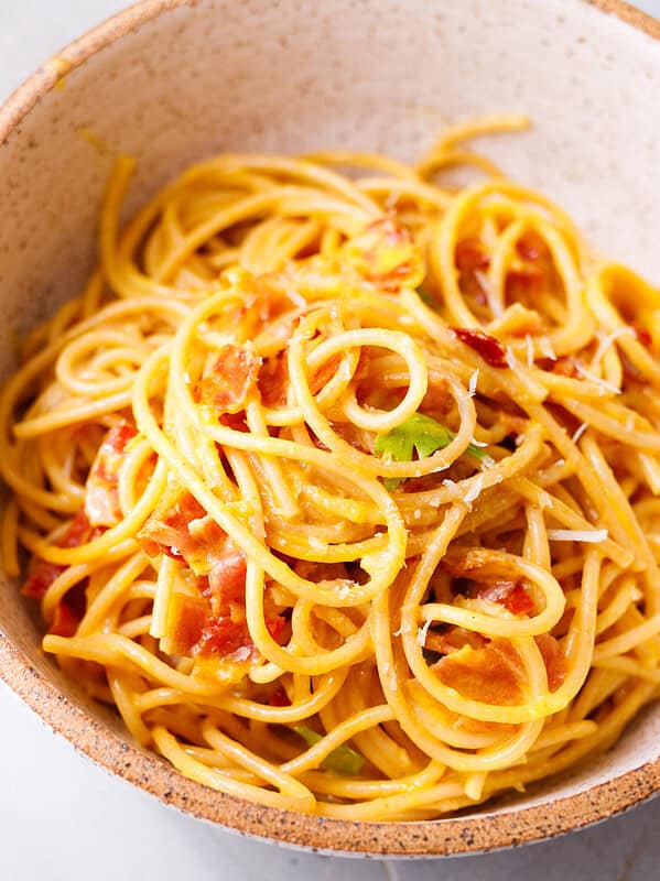 Bowl of 20 minute pasta carbonara with spaghetti, bacon, Parmesan, and parsley.