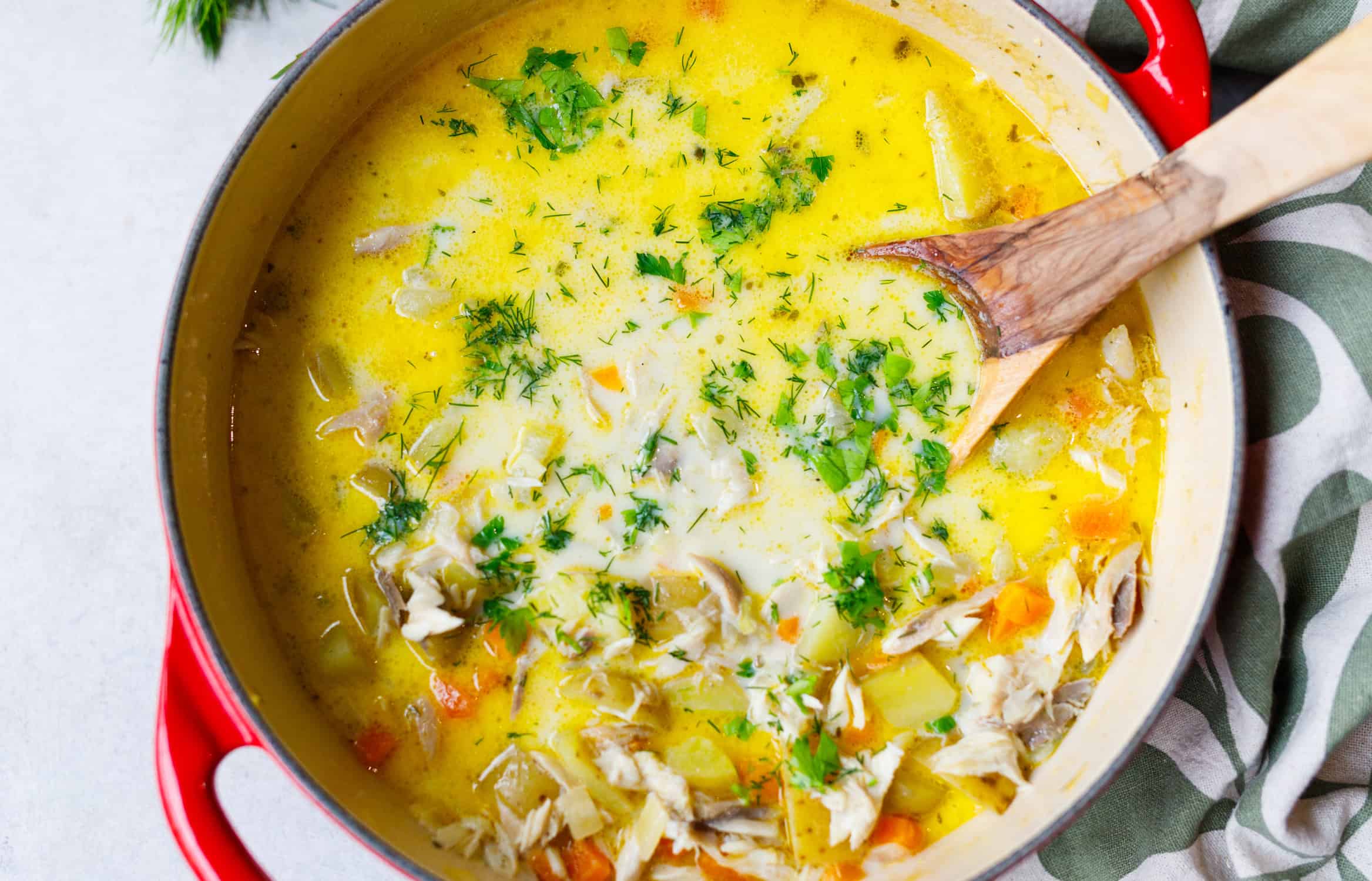 Creamy mackerel chowder in a Dutch oven garnished with fresh dill and parsley, ready to serve