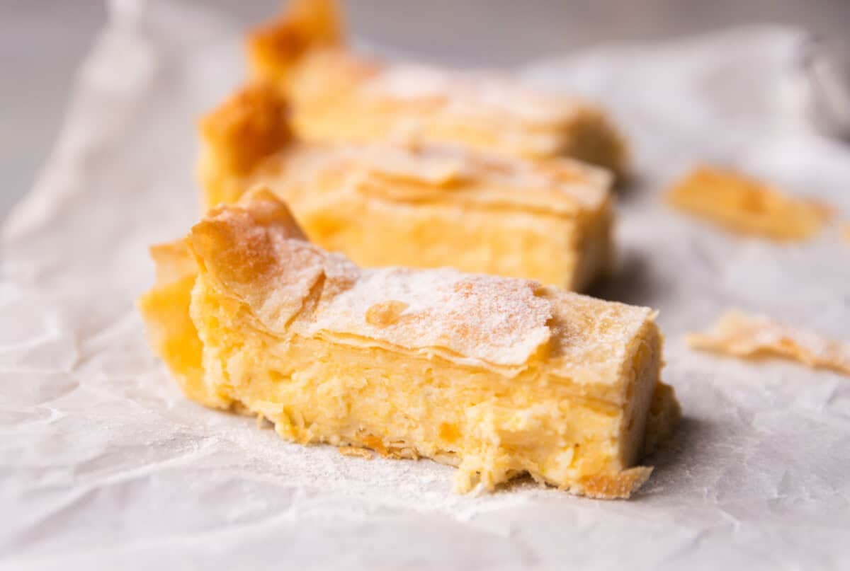 Close-up of a Greek custard pie slice showing creamy semolina custard between crispy phyllo sheets