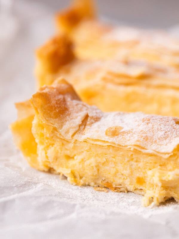 Close-up of a Greek custard pie slice showing creamy semolina custard between crispy phyllo sheets