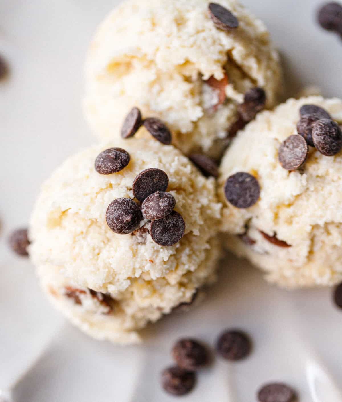 Overhead view of cottage cheese cookie dough balls with dark chocolate chips scattered around