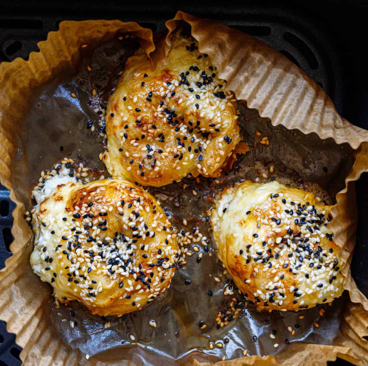 Three rice paper cheese rolls topped with black and white sesame seeds before air frying