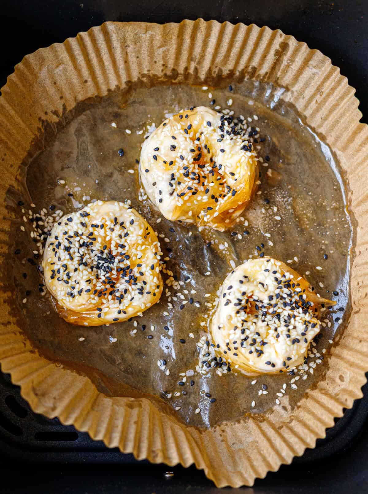 Close-up of a golden air fryer banitsa topped with toasted sesame seeds