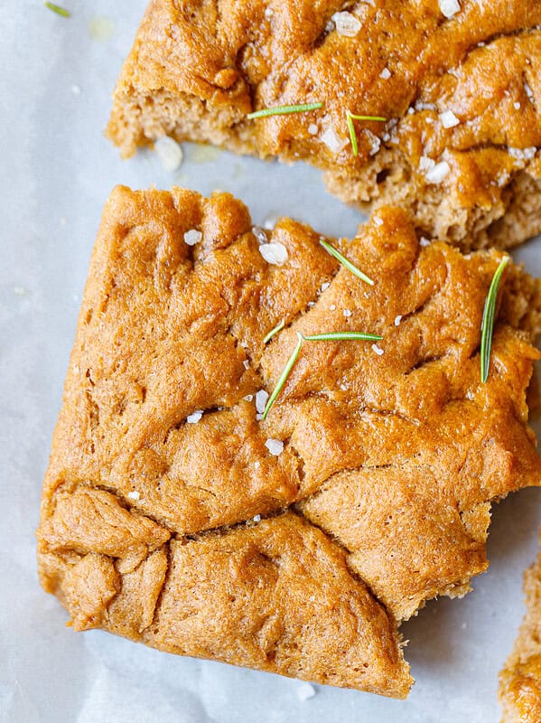 Close-up of spelt flour focaccia squares topped with rosemary sprigs and sea salt