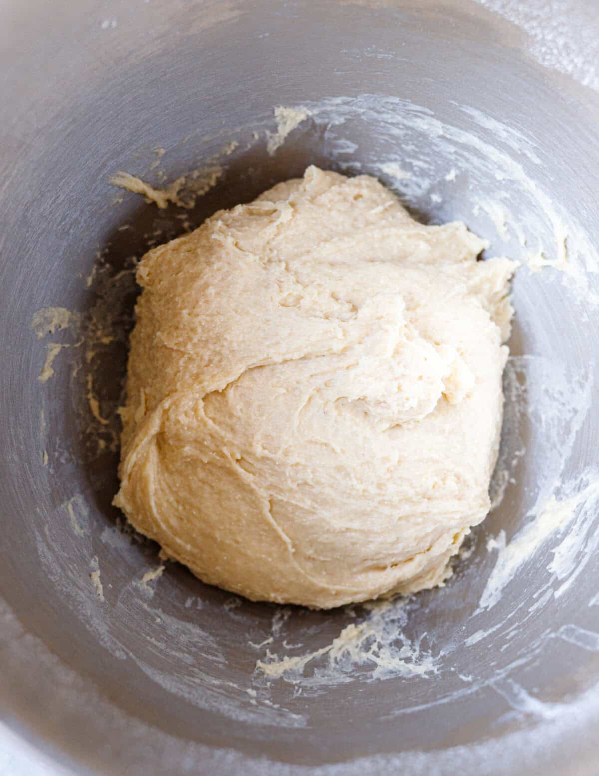 Brioche burger bun dough kneaded in a stand mixer bowl