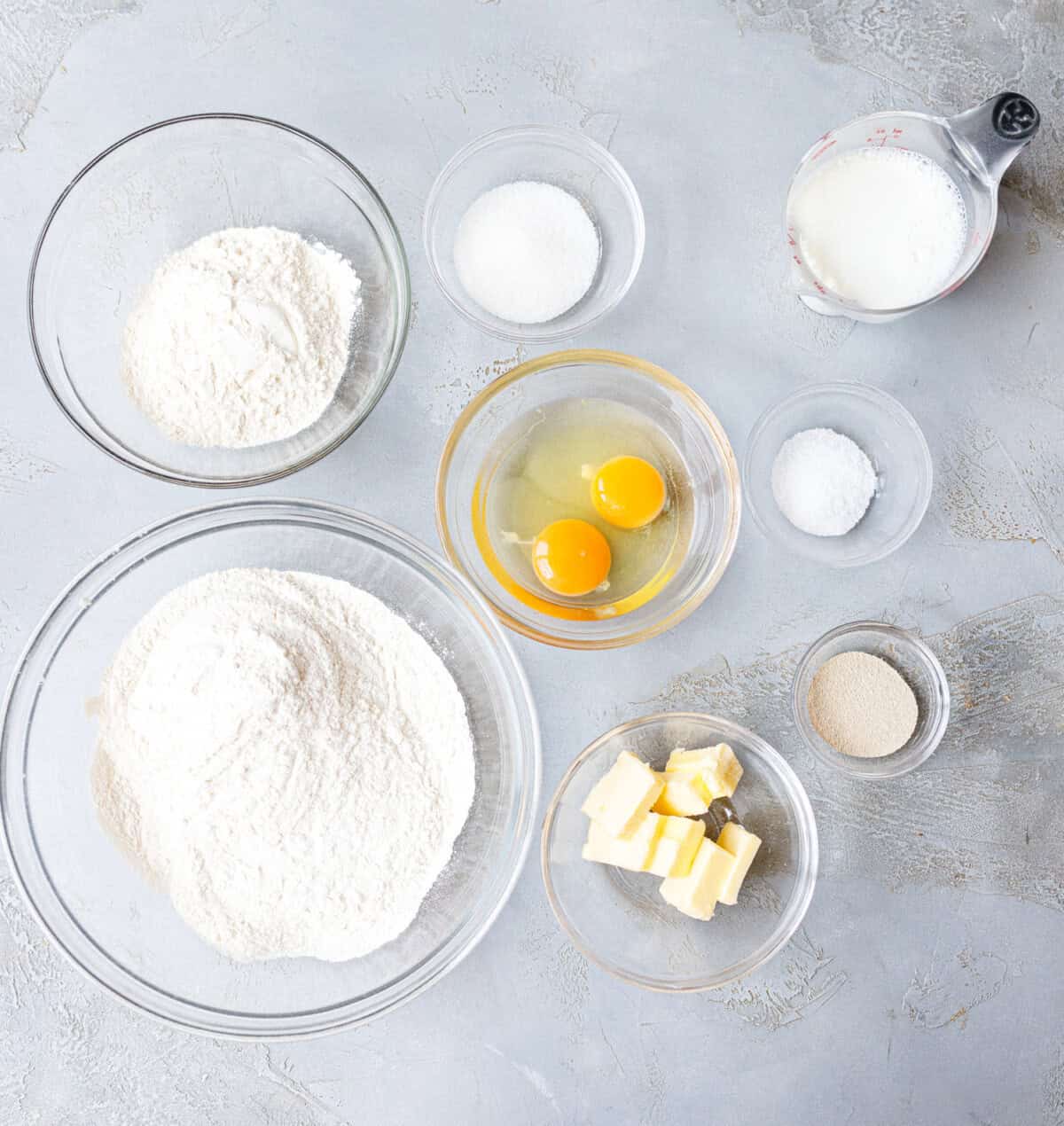 Ingredients for brioche burger buns — bread flour, eggs, butter, milk, sugar, salt, and yeast