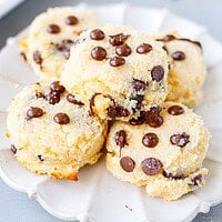 Soft chocolate chip cottage cheese cookies stacked on a white scalloped plate