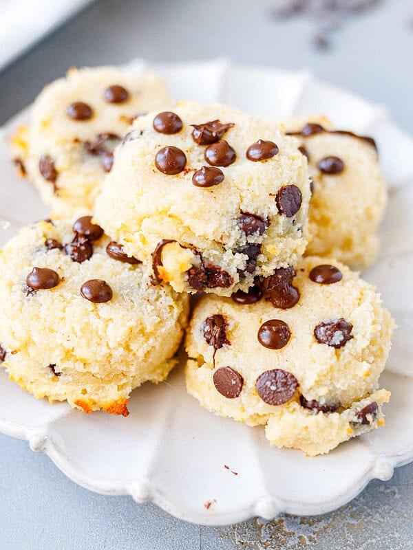 Soft chocolate chip cottage cheese cookies stacked on a white scalloped plate