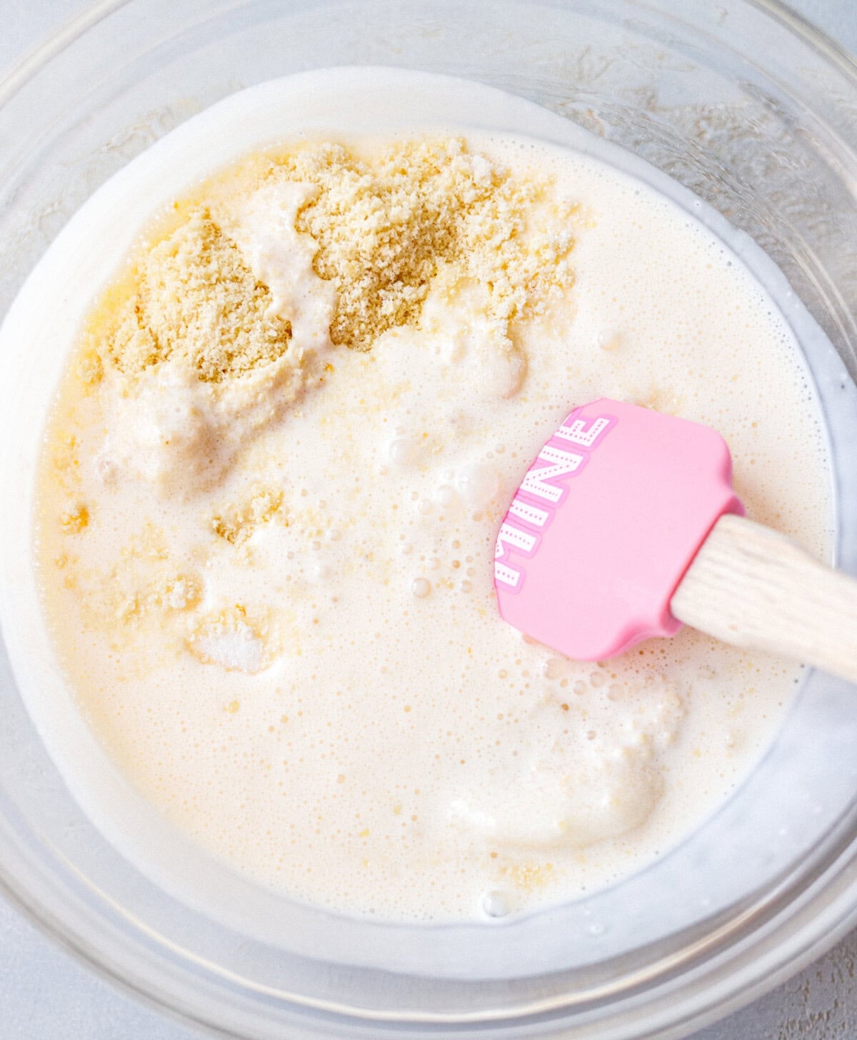 Almond flour being stirred into blended cottage cheese with a pink spatula
