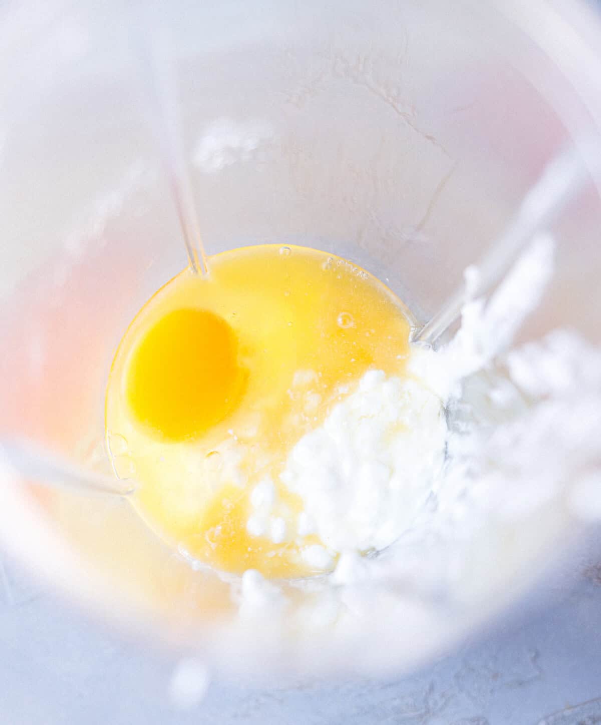 Cottage cheese and a raw egg in a blender before blending smooth