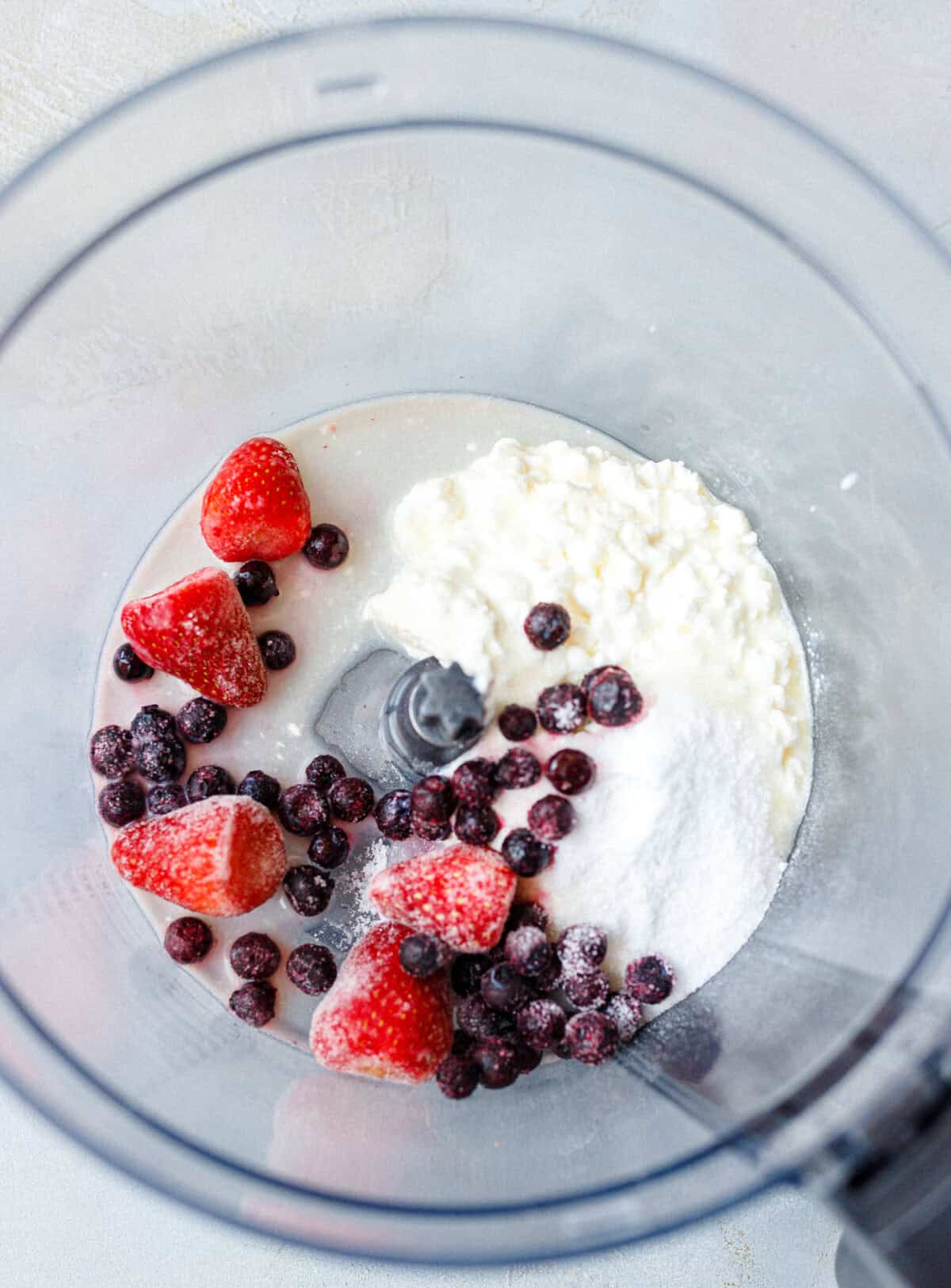 Frozen strawberries, blueberries, cottage cheese and sweetener in a food processor before blending