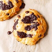 Two chocolate chip cottage cheese scones cooling on parchment paper