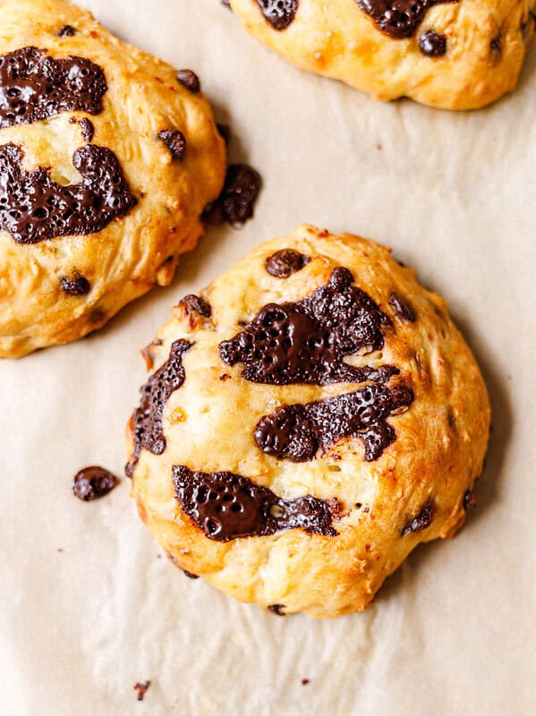 Two chocolate chip cottage cheese scones cooling on parchment paper