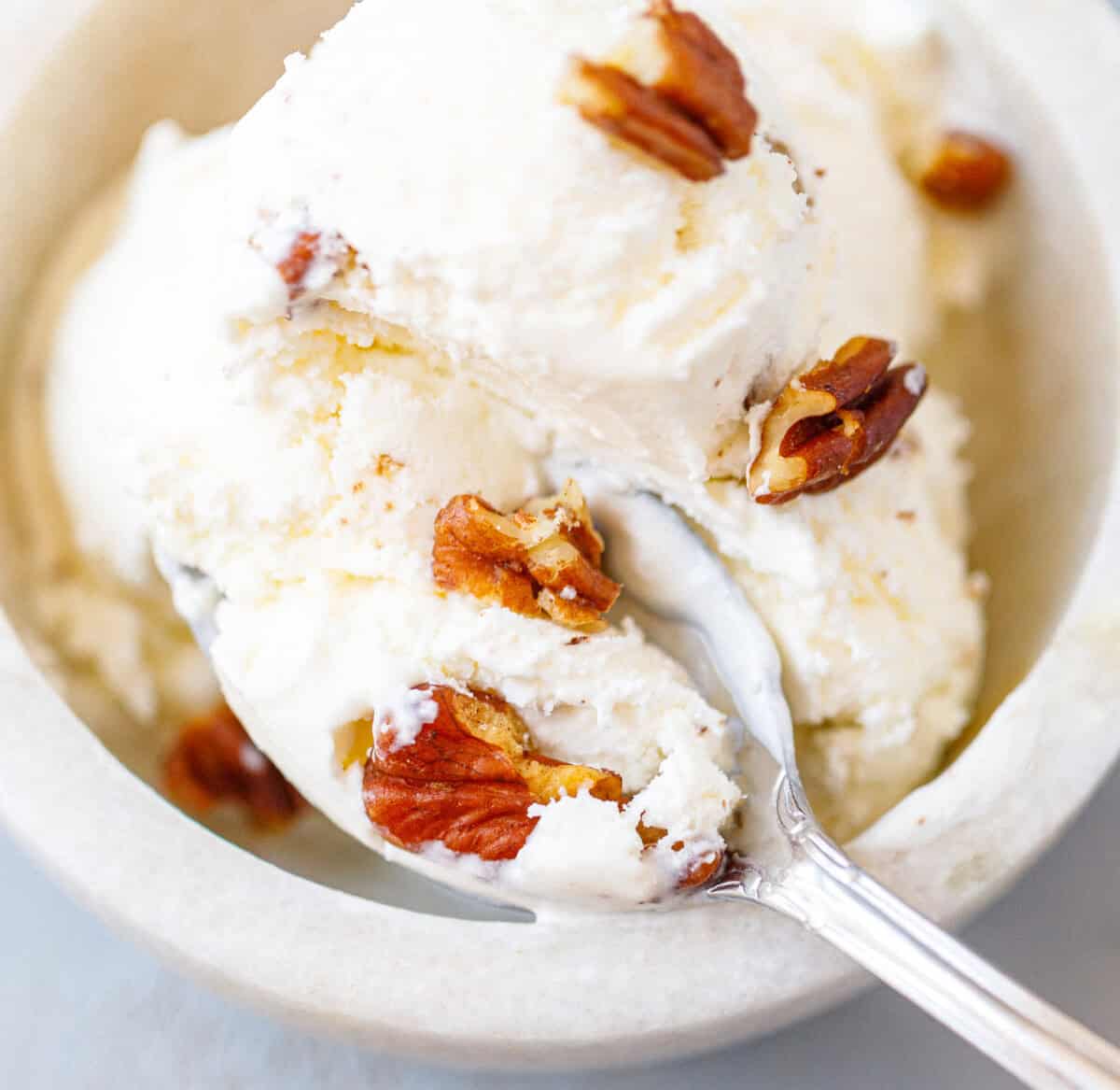 Spoonful of creamy homemade butter pecan ice cream with buttery toasted pecans.
