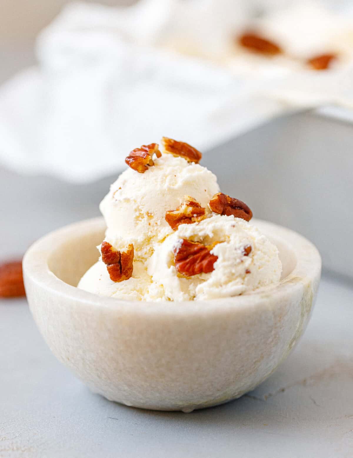 Homemade butter pecan ice cream served in a small bowl with buttery toasted pecans.