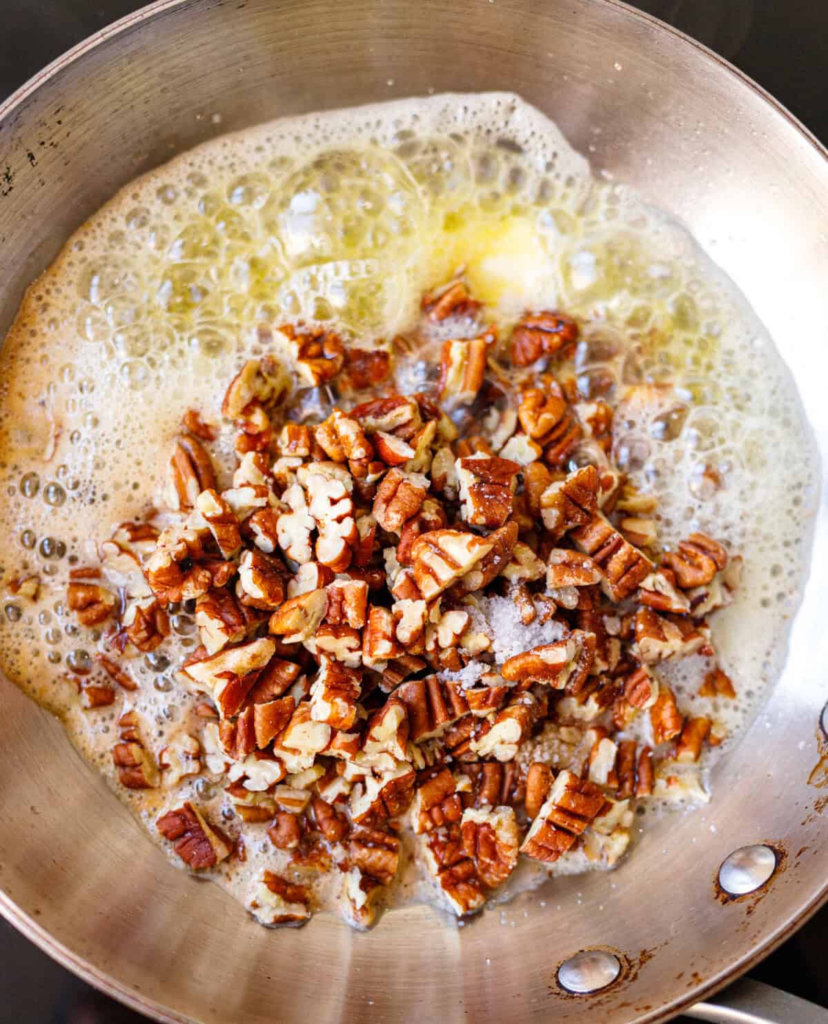 Toasted pecans coated in butter for homemade butter pecan ice cream.