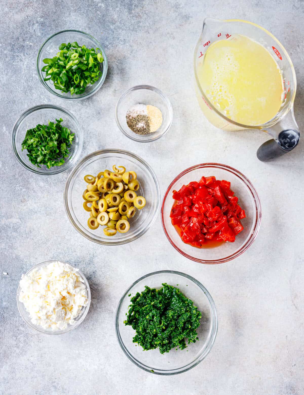 ngredients for egg white breakfast cups — liquid egg whites, spinach, roasted red peppers, green olives, feta, green onion, parsley, salt, pepper and garlic powder